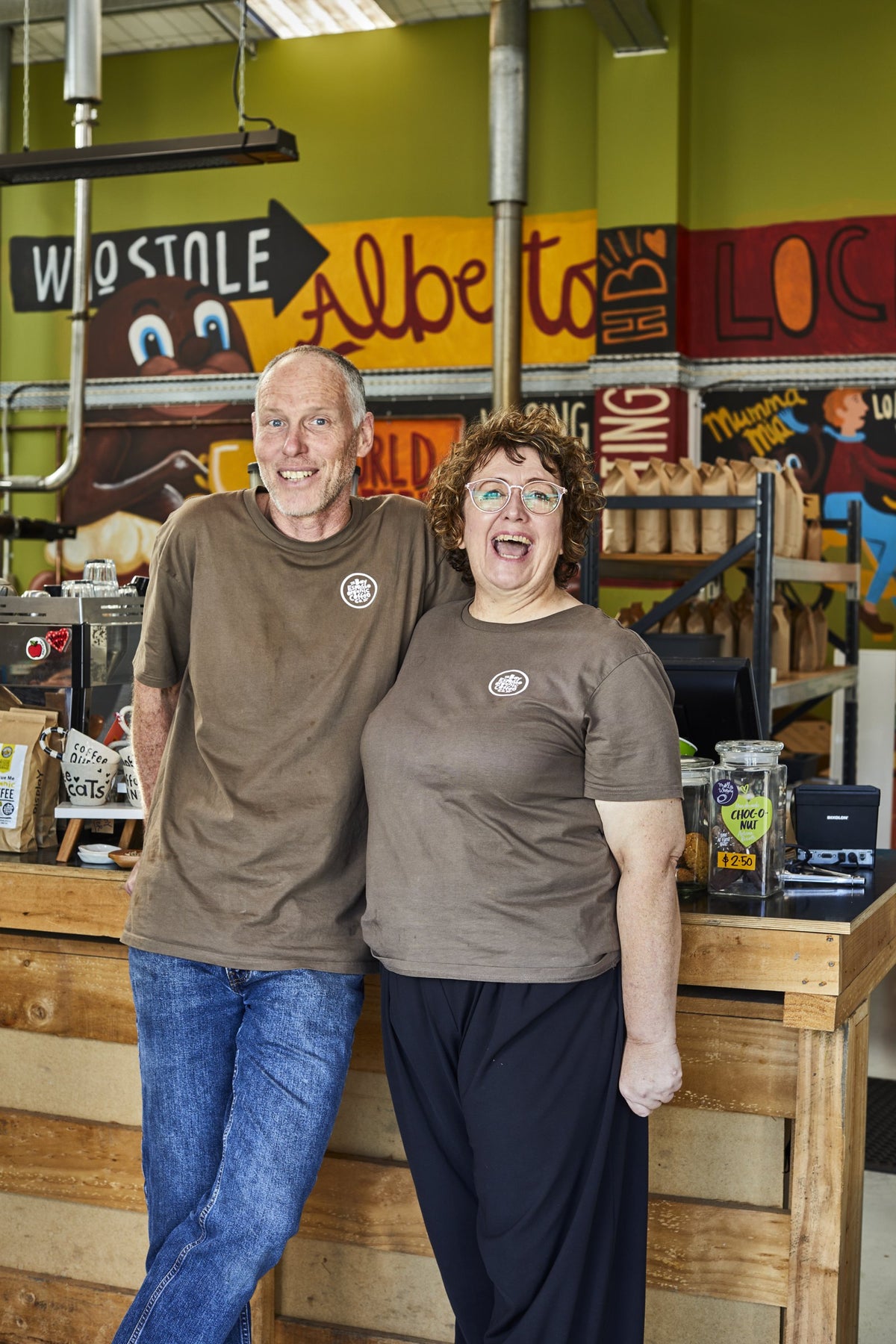 Chris and Jonelle Jarvis laughing together at the counter in the Bay Espresso roastery