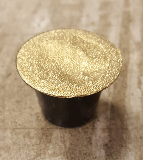 A Nespresso-compatible coffee pod with a gold lid